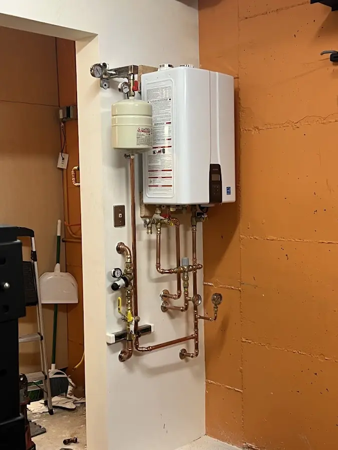 Plumbing technician inspecting water heater connections in Viroqua